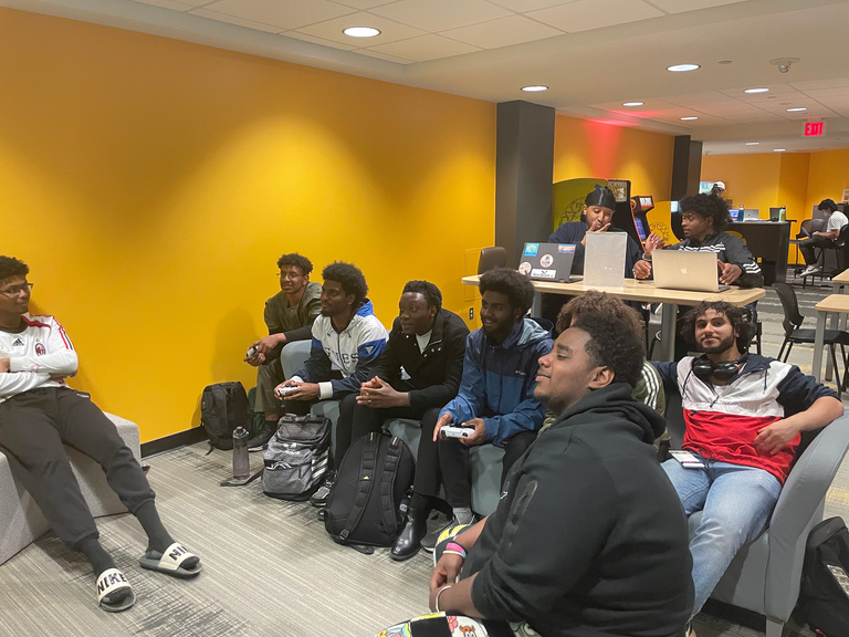 students sitting on couch playing video games