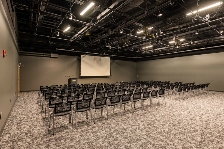 black box theater with video screen and chairs