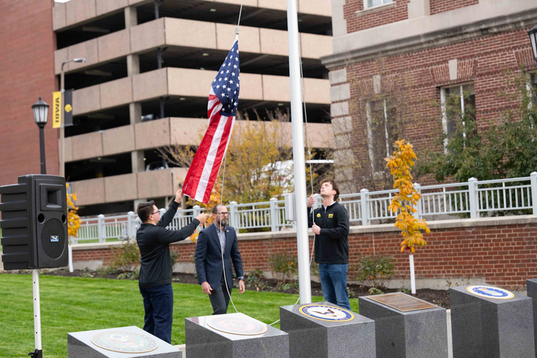raising flag during Veterans Plaza Dedication