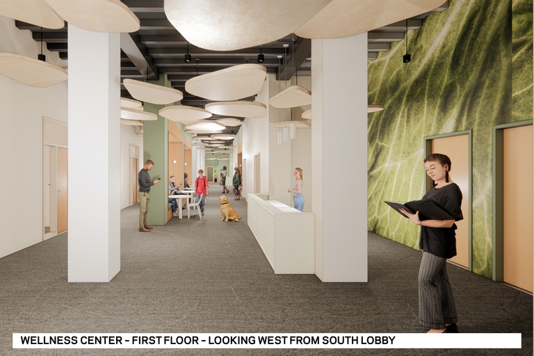 Future Wellness Center space on 1st floor with a therapy dog and people gathered.