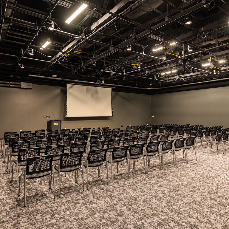 black box theater with video screen and chairs