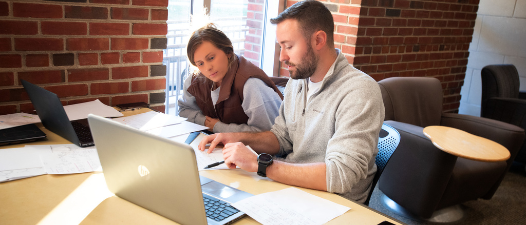 students at table with laptop