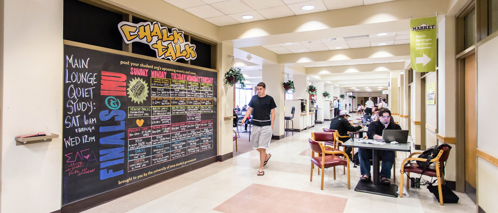 A student walking past the chalkboard in the River Room