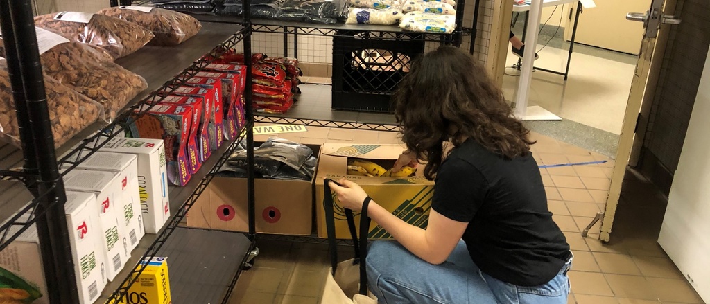 A person unpacking a box of food at the Food pantry