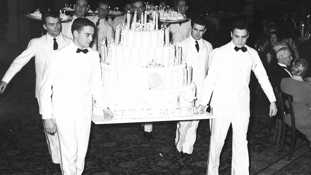 waiters holding a large cake