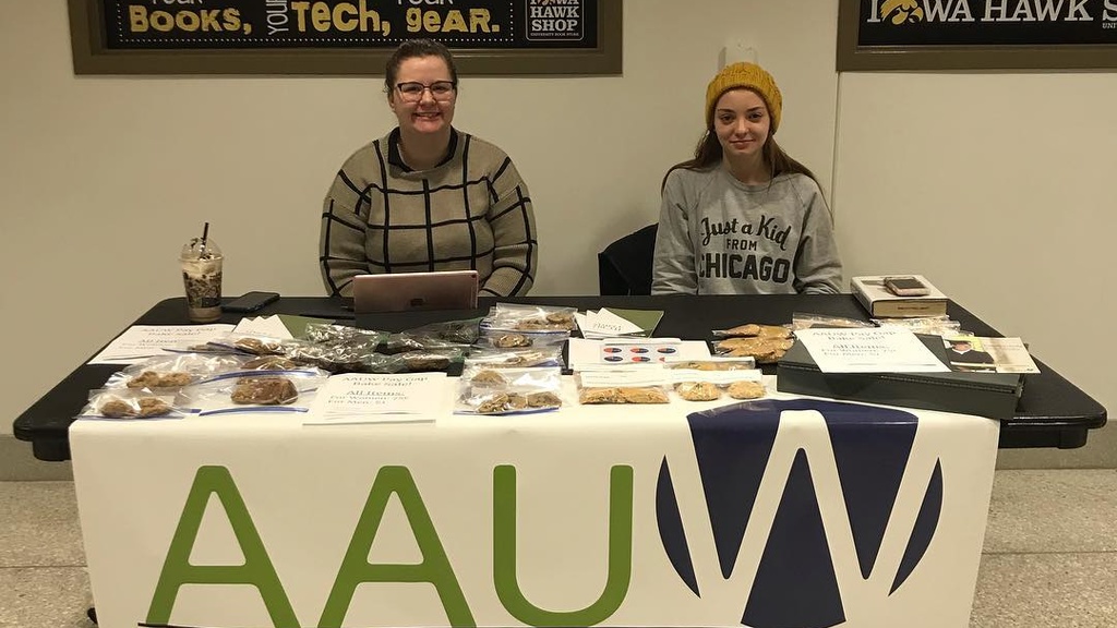 two students at table selling baked goods