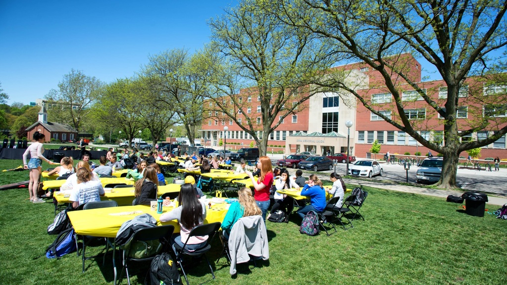 group of student outside sitting at tables